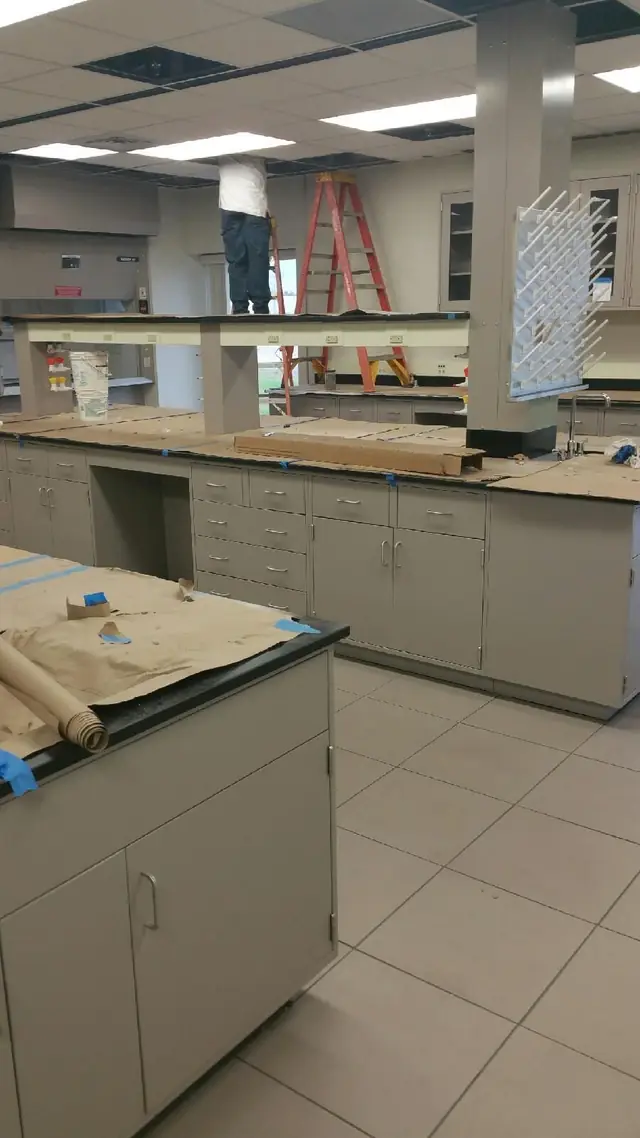 Newly installed laboratory casework being prepared and cleaned after construction work