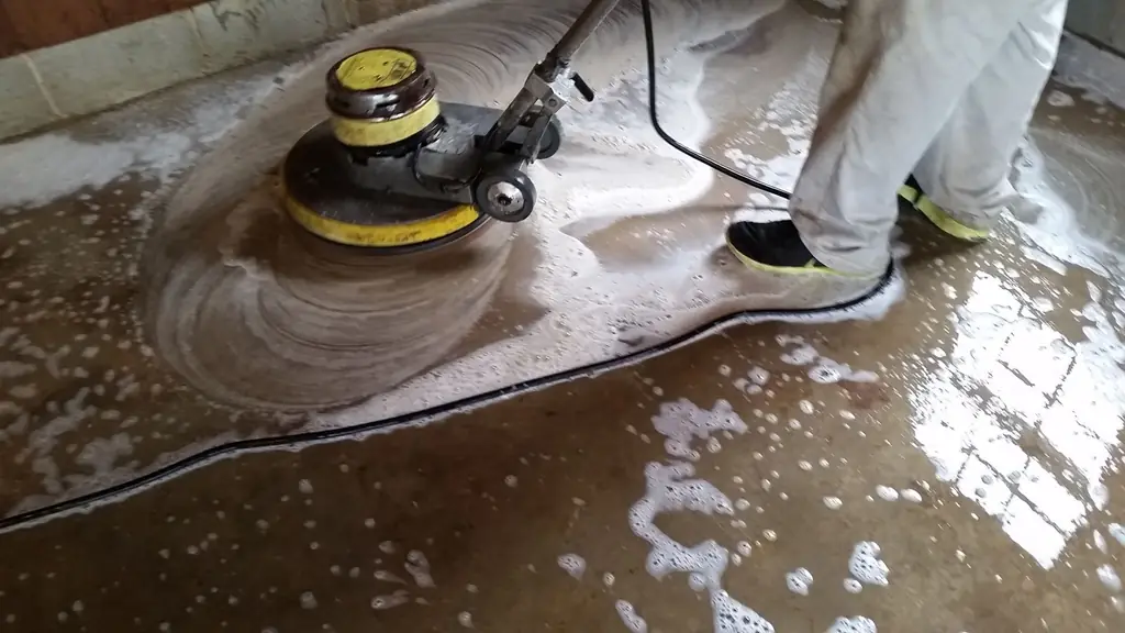 Close view of a floor machine pad working through foam on a concrete floor