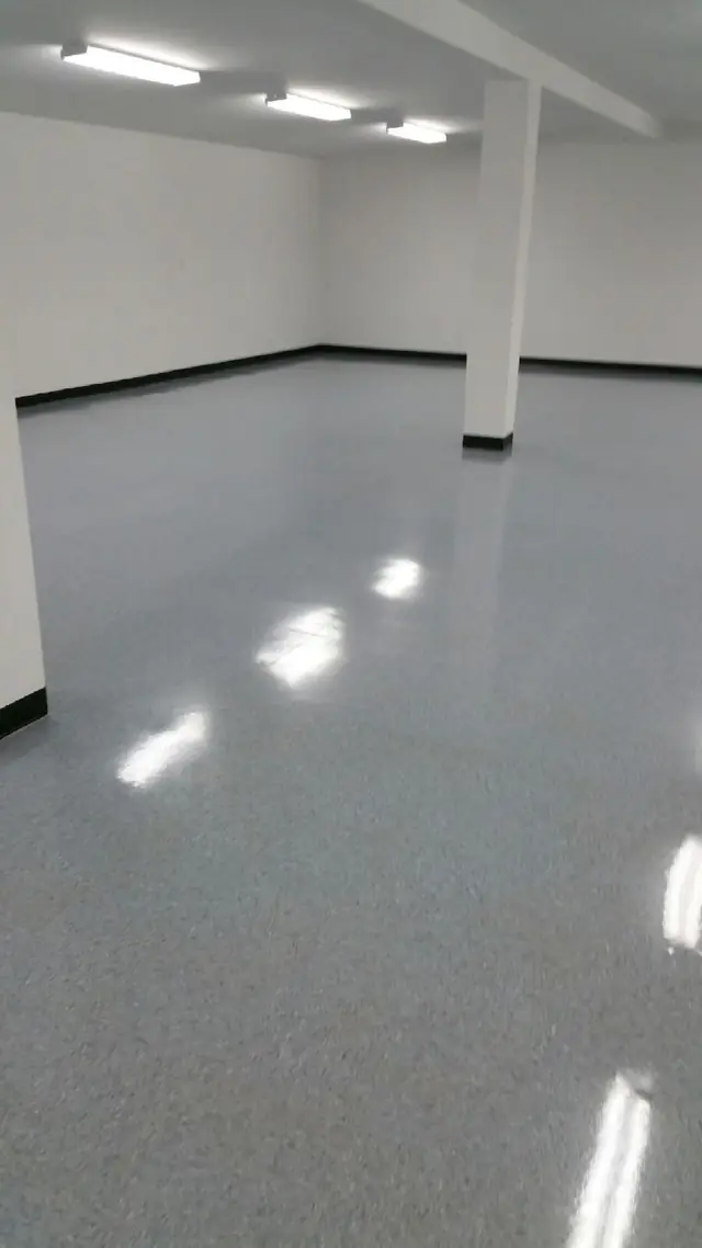 A polished terrazzo floor reflecting overhead lighting