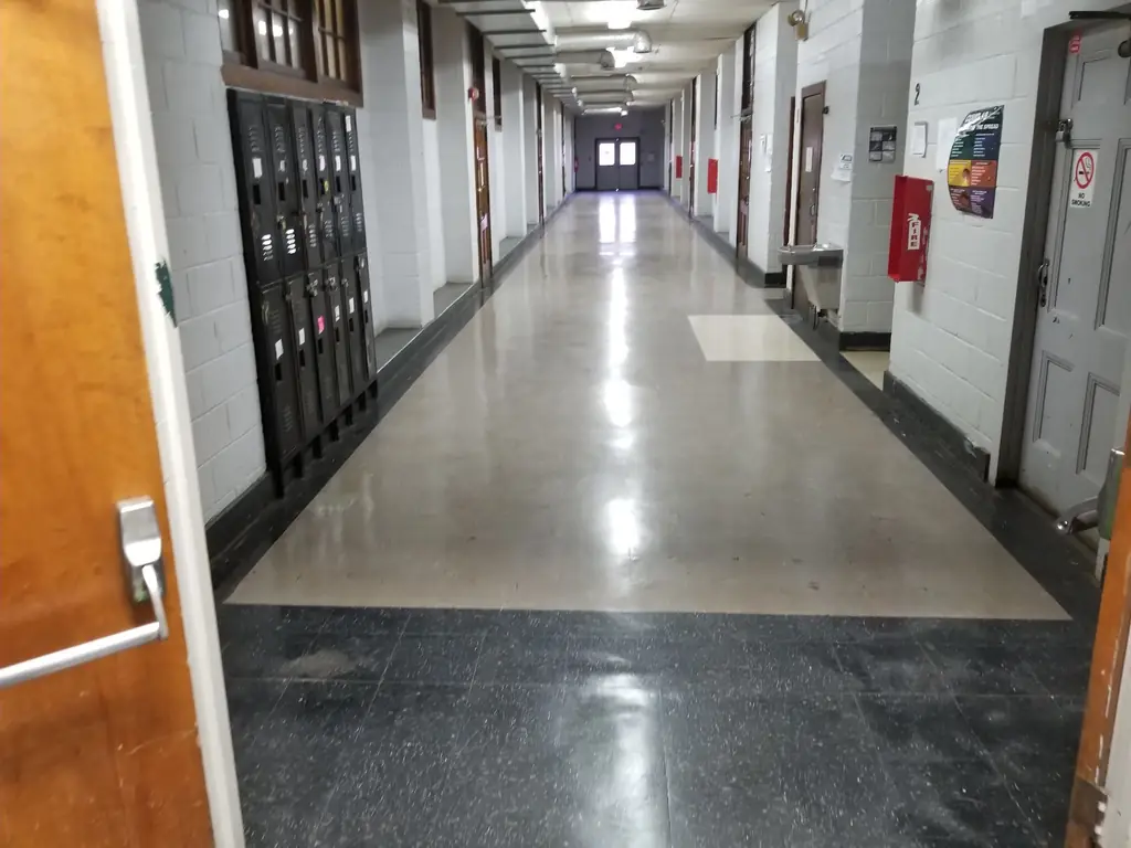 A long school corridor with a polished floor running into the distance